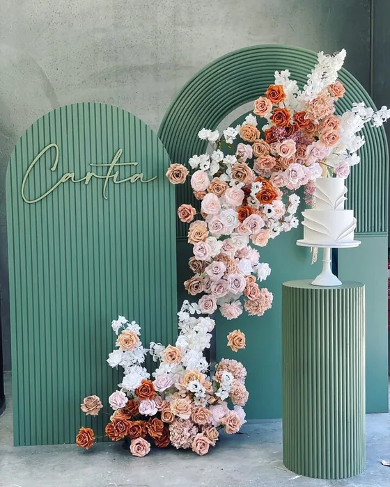 Sage green ripple arch dressed with a cascade of blush and white flowers