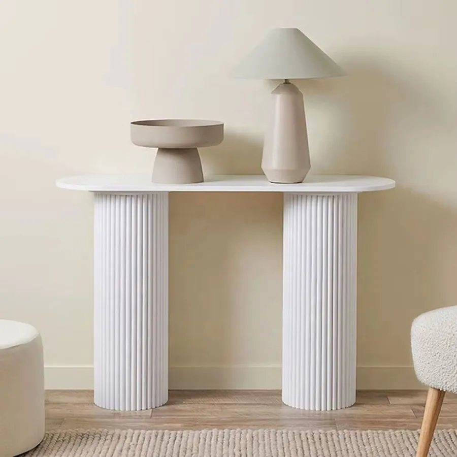 White fluted console table styled with a lamp and ceramics