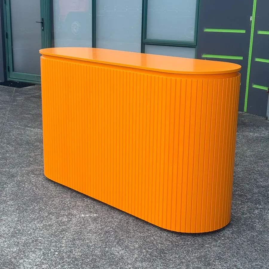 Fluted racetrack reception counter finished in bright orange