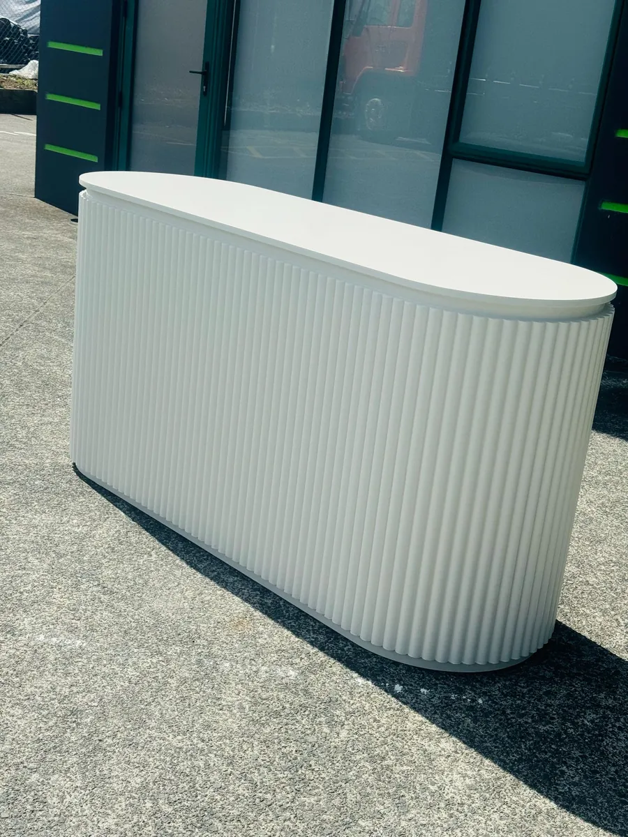 Fluted racetrack reception counter finished in sage green