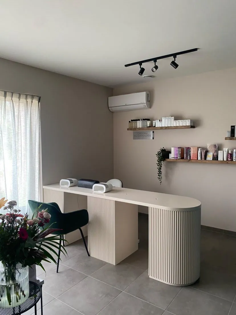 Nail salon fitout with a long bench, wall shelving and an arched mirror