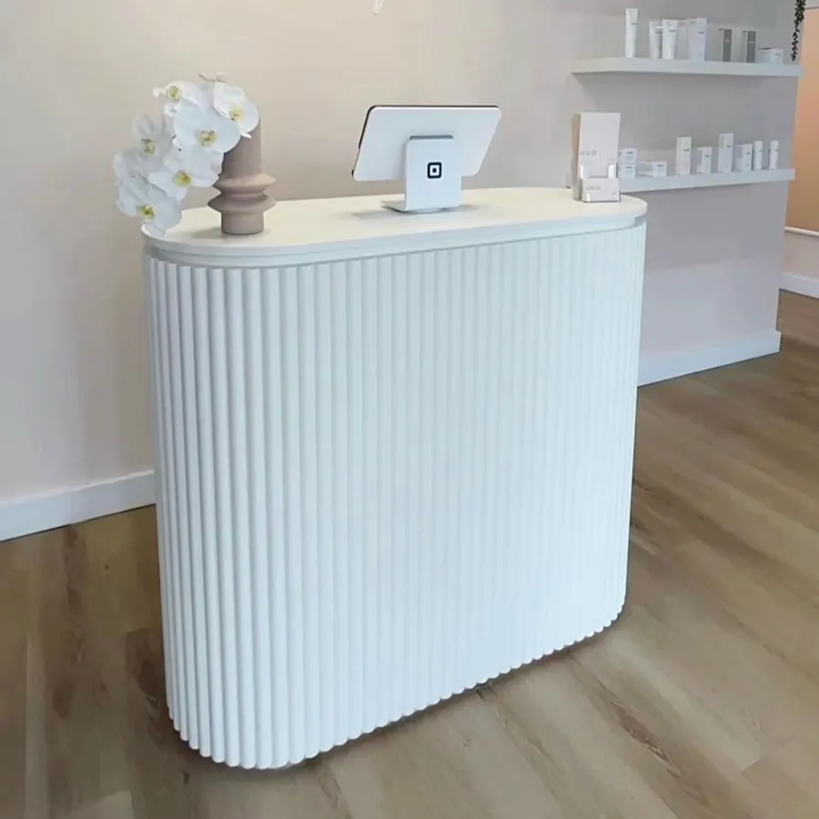 White fluted salon counter on a pale timber-look floor