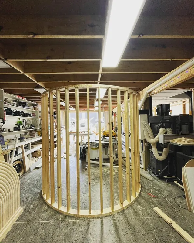 Gold slatted cylinder standing on a workshop floor