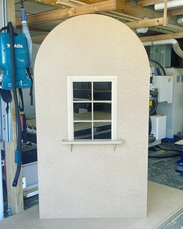 Cream arch backdrop with a small square window opening