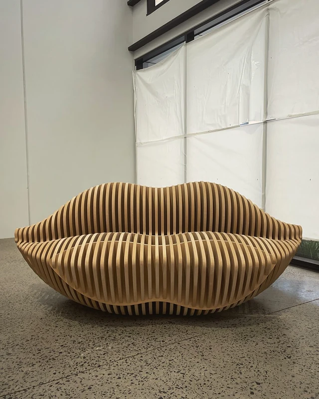 A sliced-rib sofa shaped like a pair of lips, cut from stacked board