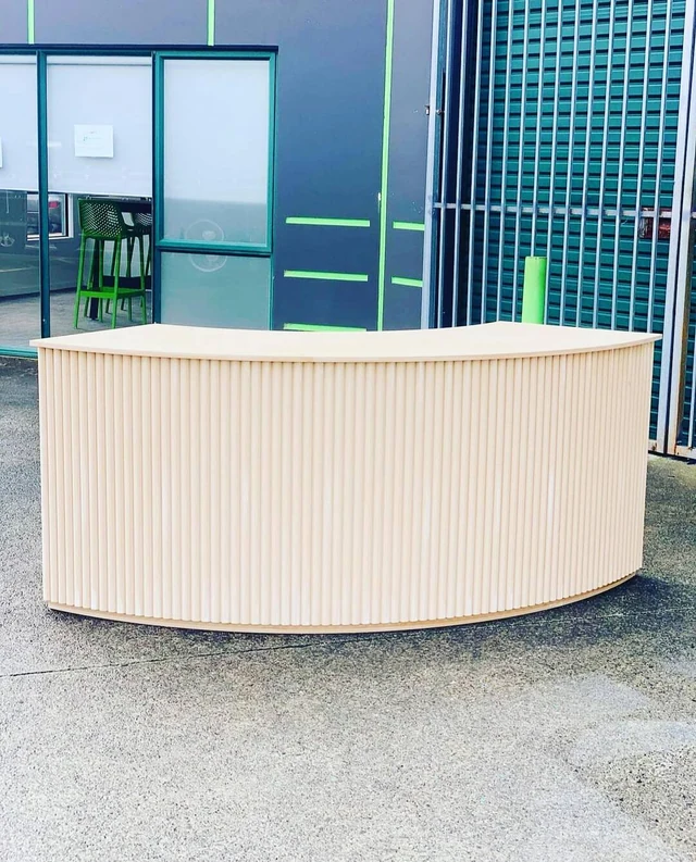 Cream curved counter photographed outside a glazed building before installation