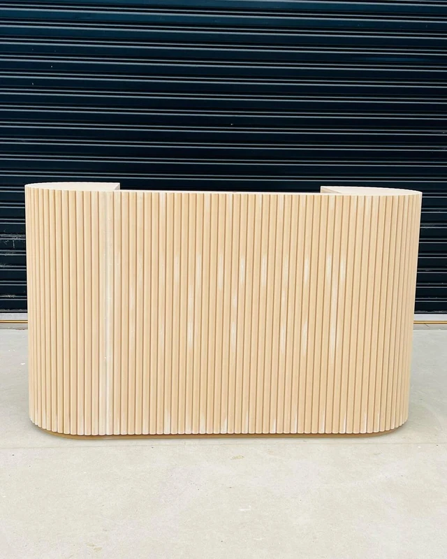 Blonde fluted counter in raw board, photographed against a roller door