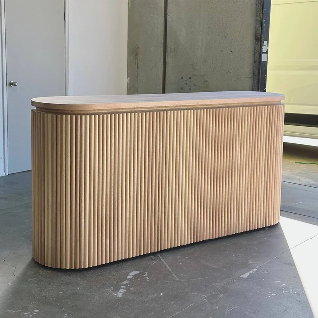 Long radius reception counter in timber-look fluting with a darker timber-look top