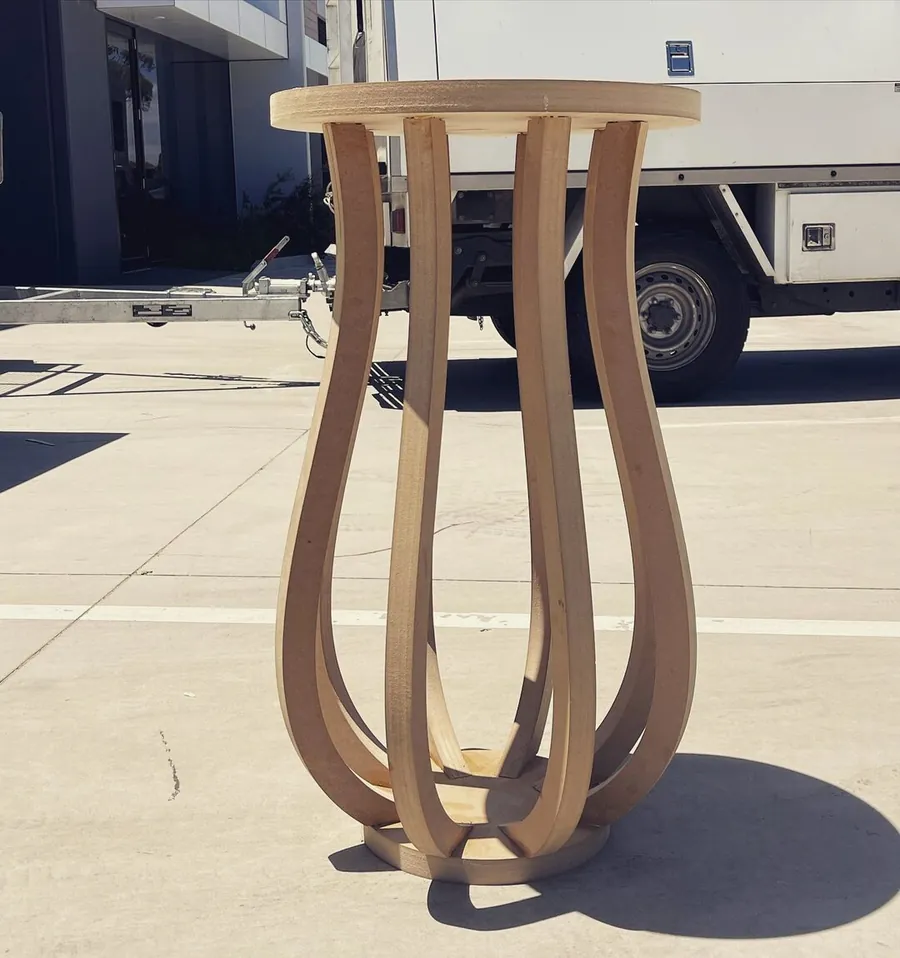Round timber-look side table built from curved parametric legs