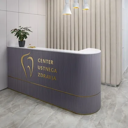 Mauve curved reception counter with a gold logo and a fluted wall behind