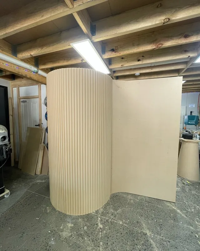 Curved cream partition wall part-built in the workshop